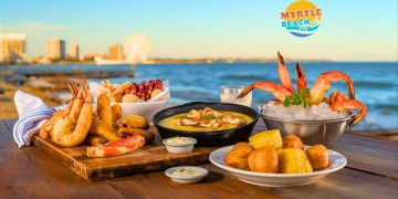 Myrtle Beach signature dishes including calabash fried shrimp, shrimp and grits, seafood boil, and hushpuppies arranged on coastal table